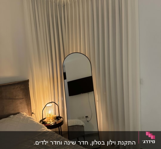 וילון לבן ארוך תלוי בפינת החדר